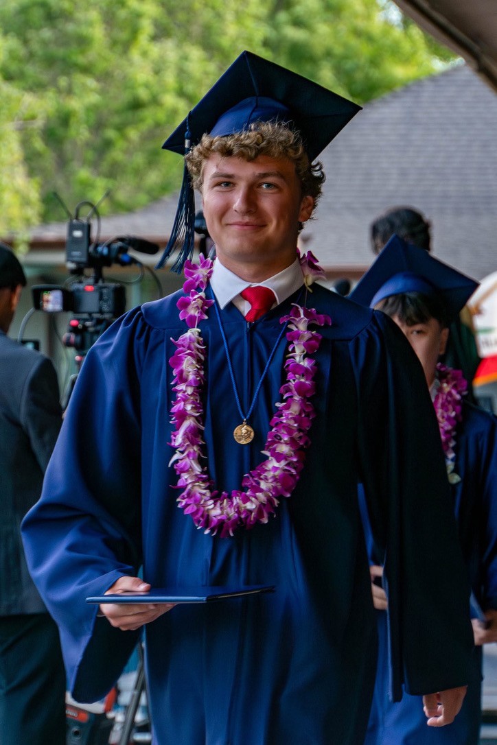 Jake at graduation ceremony in cap and gown.